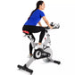 Woman wearing blue short-sleeve top and black leggings with red waistband, exercising on Spirit XIC600 stationary indoor bike