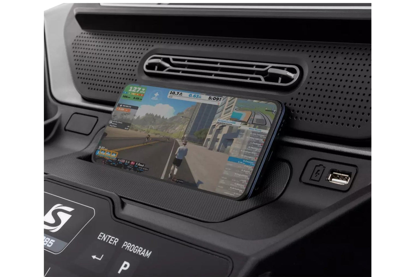 Smartphone displaying fitness tracking app with running workout data, positioned on black car dashboard with ventilation gril