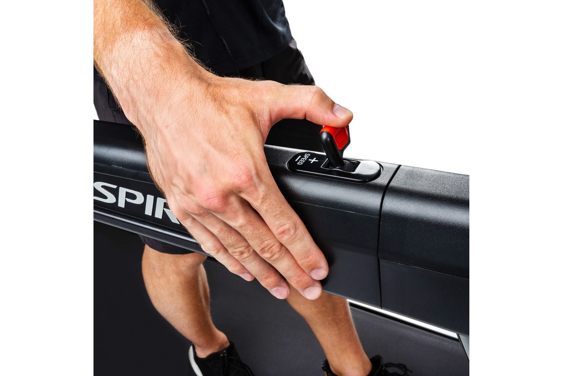 Man's hand gripping black treadmill handlebar with red button, demonstrating grip on Spirit XT485 treadmill