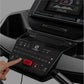 Black treadmill console with digital display, numbered speed buttons, red stop button, and hand operating control panel
