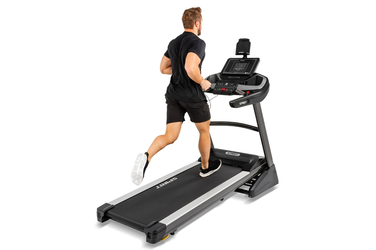 Man jogging on black and silver Spirit XT485 treadmill with digital console display, worn on white background