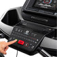 Treadmill console display showing digital screen with speed and metrics, black control panel with red emergency stop button, 