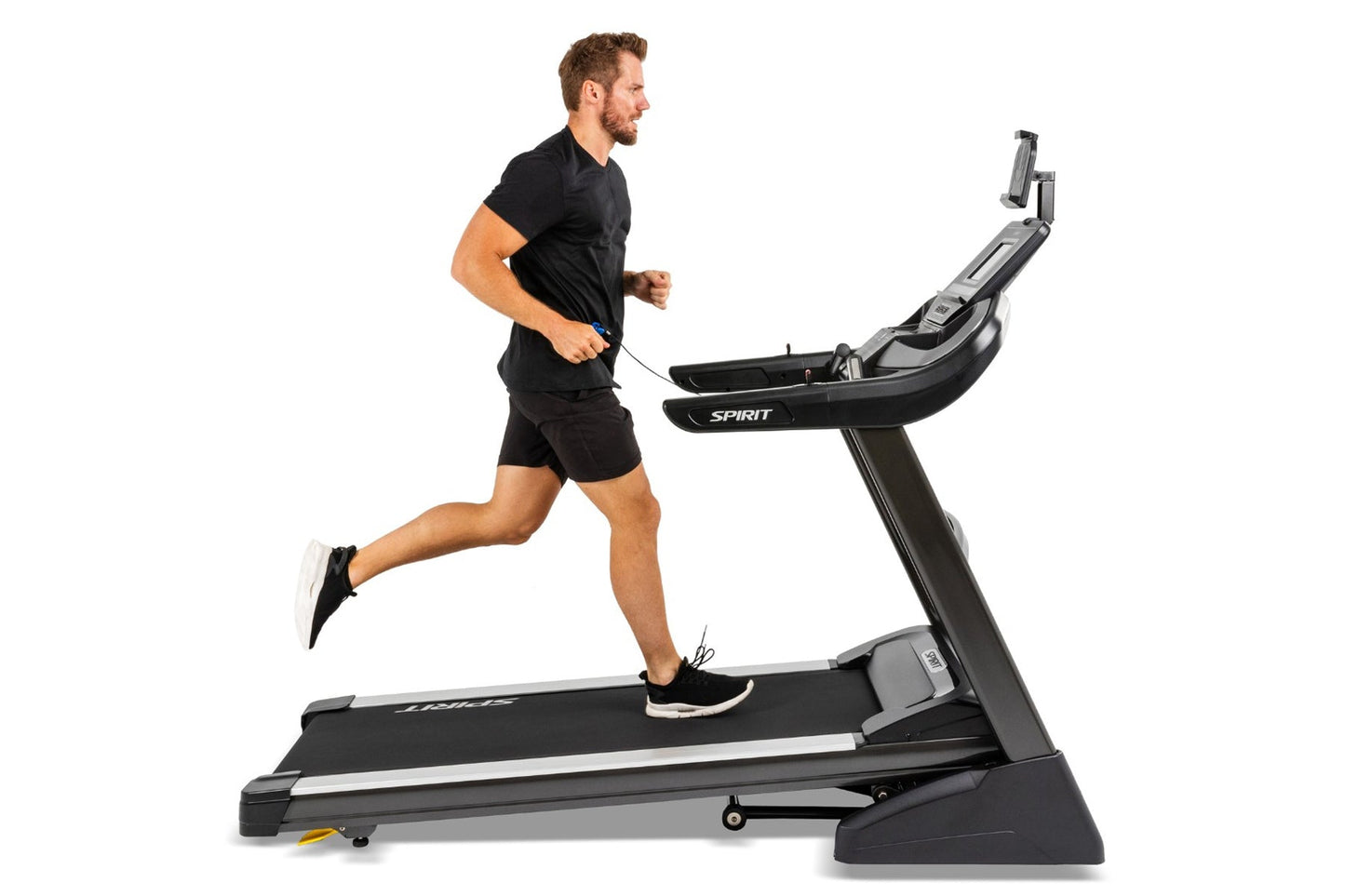 Man in black shirt and shorts running on Spirit XT485 treadmill with digital display, shown from side view on white backgroun