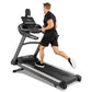 Spirit XT685ENT black and gray treadmill with digital display, worn by male model in black shirt and shorts