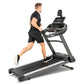 Man running on Spirit XT685ENT black and gray treadmill with digital display monitor, worn by model on white background
