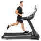 Man in black shirt and shorts running on Spirit XT685ENT treadmill with digital display against white background