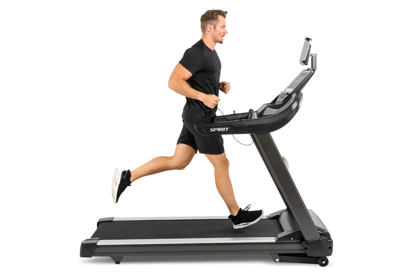 Man in black shirt and shorts running on Spirit XT685ENT treadmill with digital display against white background