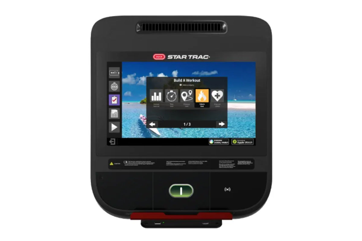 Star Trac black fitness machine with touchscreen display showing workout interface and tropical beach background image
