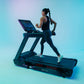 Woman running on black Star Trac treadmill with digital display against turquoise gradient background