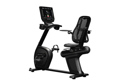 Black recumbent stationary bike with digital display console, mesh backrest, and foot pedals on white background