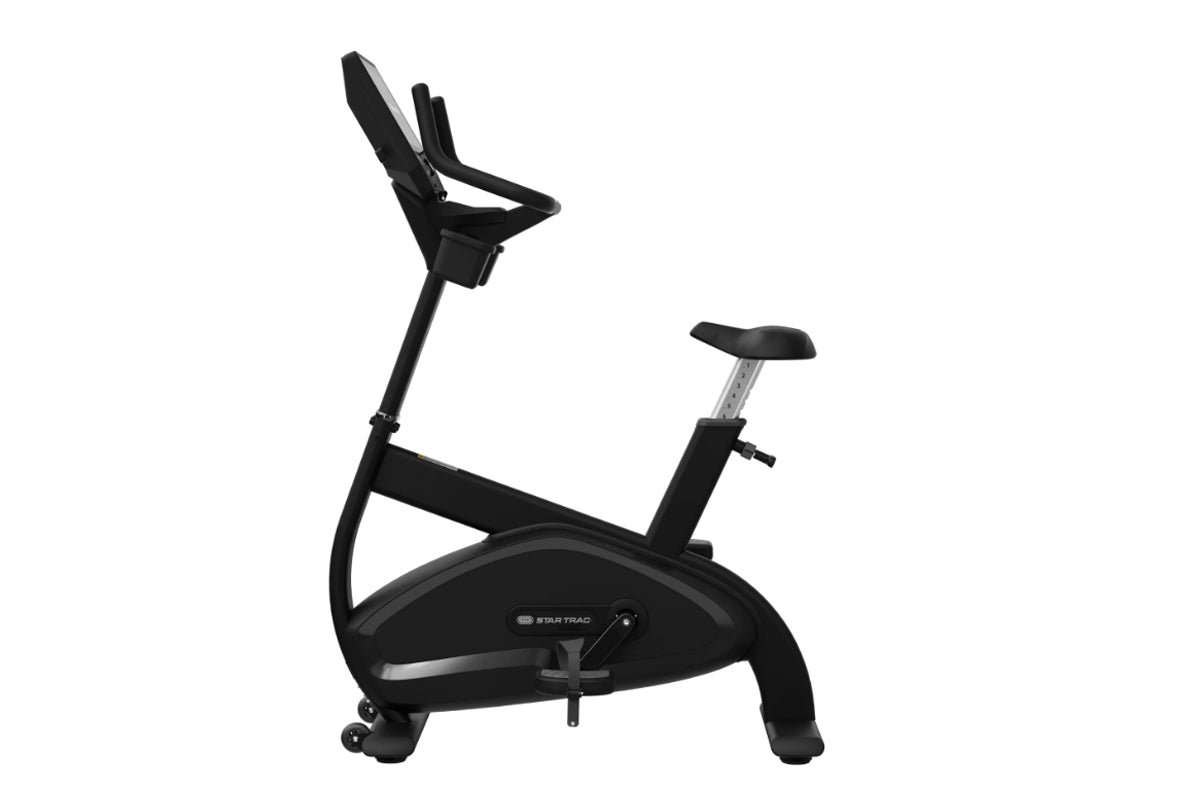 Black upright stationary exercise bike with padded seat, handlebar console, and digital display on white background