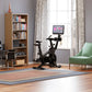 Black stationary exercise bike with digital display screen mounted on top, positioned in home gym setting