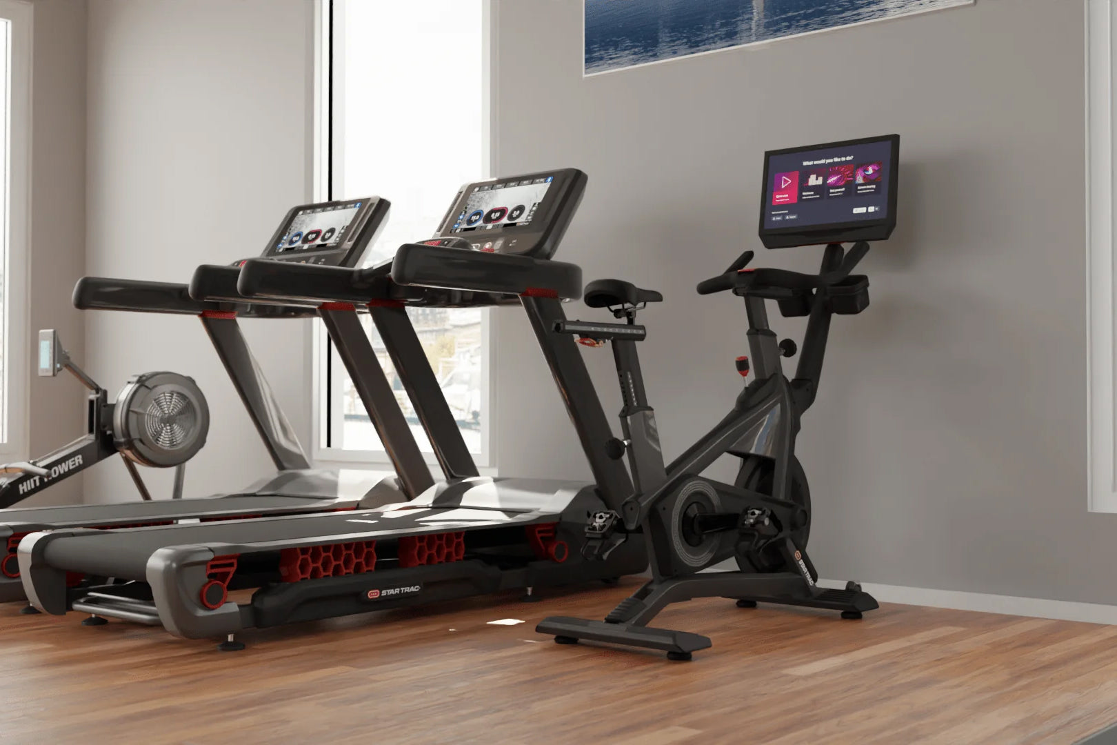 Home gym setup with black and red Star Trac exercise equipment including treadmills, stationary bike, and digital displays on