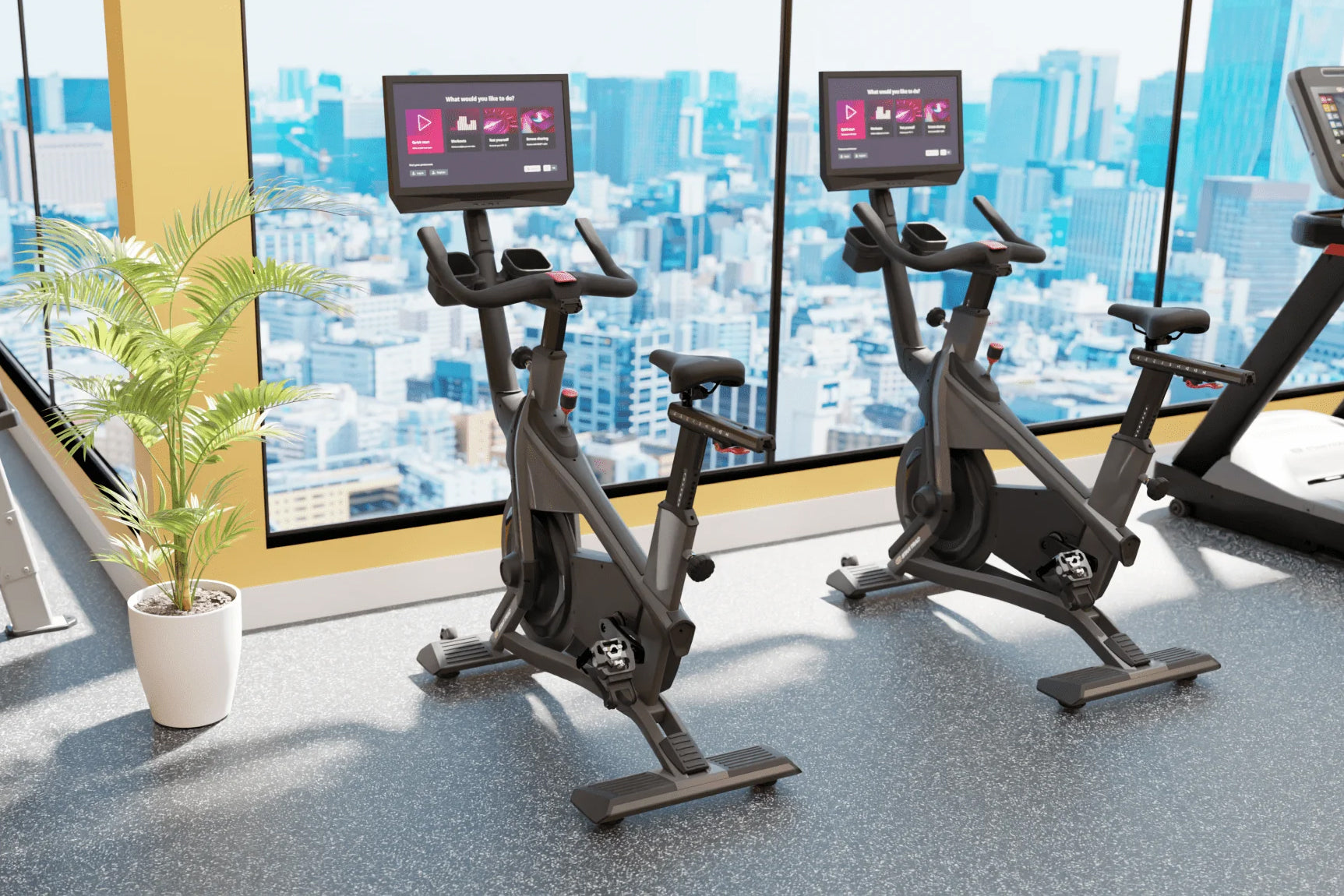 Black stationary exercise bikes with tablet screens in modern gym overlooking city skyline