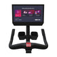 Black stationary exercise bike with curved handlebars, dual foot pedals, red accent button, and mounted display screen showin