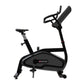 Black and gray Star Trac upright exercise bike with padded seat, handlebars, and digital display console on white background