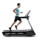 Man in turquoise t-shirt and black shorts running on black and silver treadmill against white background