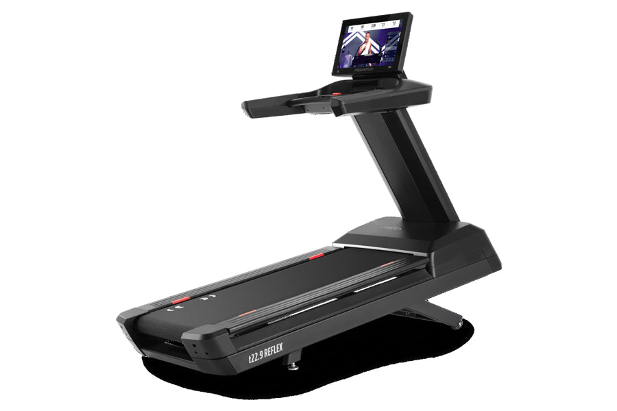 Black Freemotion t22.9 REFLEX treadmill with wide running deck, upright console displaying workout screen, on white backgroun