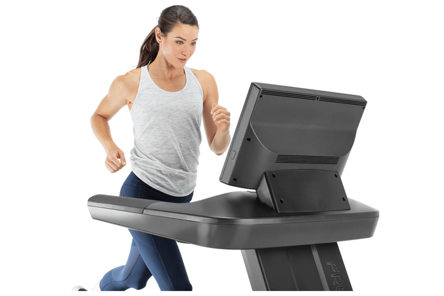 Woman running on black and gray Freemotion T22.9 REFLEX treadmill with digital display, wearing white tank top and blue leggi