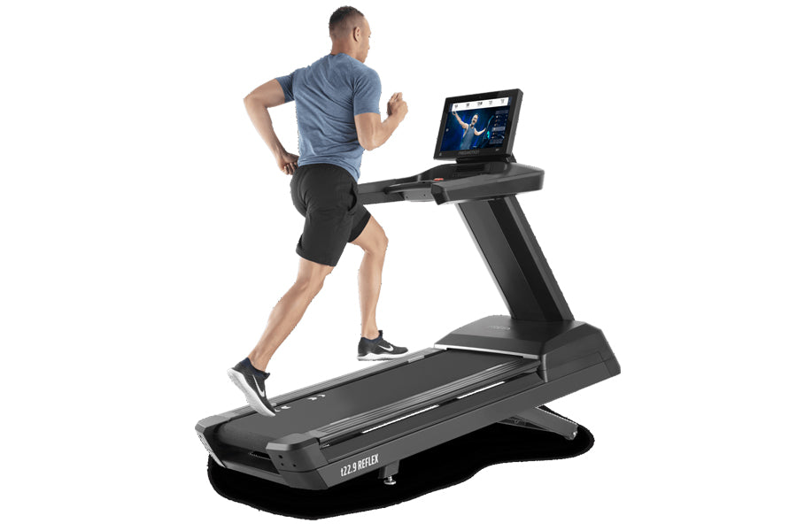 Man running on black Freemotion t22.9 REFLEX treadmill with tablet display, worn by model on white background