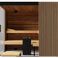 Thermasol Aalto indoor sauna with dark wood interior, light wood benches, glass door, and vertical slat exterior paneling