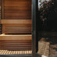 Thermasol Nordic Misty outdoor sauna with light wood interior, horizontal slat benches, and open door view of garden setting