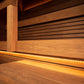 Interior of wooden sauna with horizontal slat walls, vertical post, bench seating, and ambient warm lighting