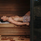 Man relaxing in wooden sauna wearing blue and gold patterned swim shorts