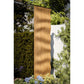 Natural wood vertical slatted outdoor sauna with wavy rippled surface in garden setting surrounded by green foliage