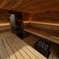 Interior view of wood sauna with built-in benches, black stove with heated rocks, and ambient lighting on white background