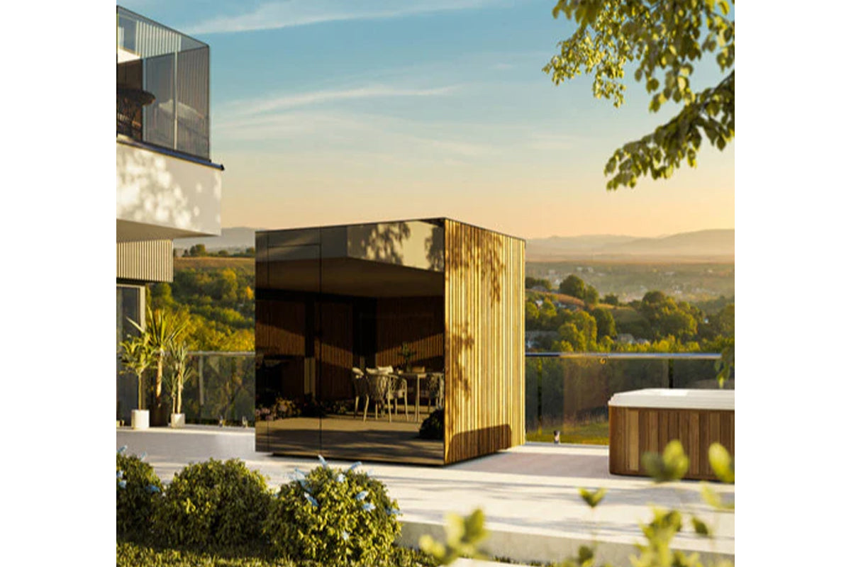 Modern outdoor sauna with golden vertical wood slats and glass doors on elevated terrace overlooking landscape