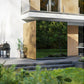 Modern wooden outdoor sauna with large glass doors and vertical slat cladding on contemporary patio