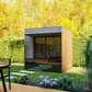 Modern outdoor sauna with natural wood siding and dark gray top, glass door entry, and wooden deck, set in landscaped garden 