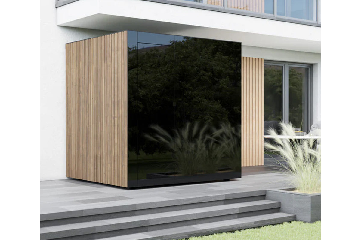 Modern outdoor sauna with natural wood slat siding and black glass corner panel on concrete patio