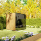 Modern outdoor sauna with natural wood and charcoal exterior in garden setting with hedges and flowering plants
