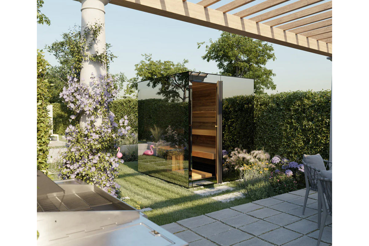 Modern outdoor sauna with black frame and wood interior door in landscaped garden setting with flowering vines and pergola