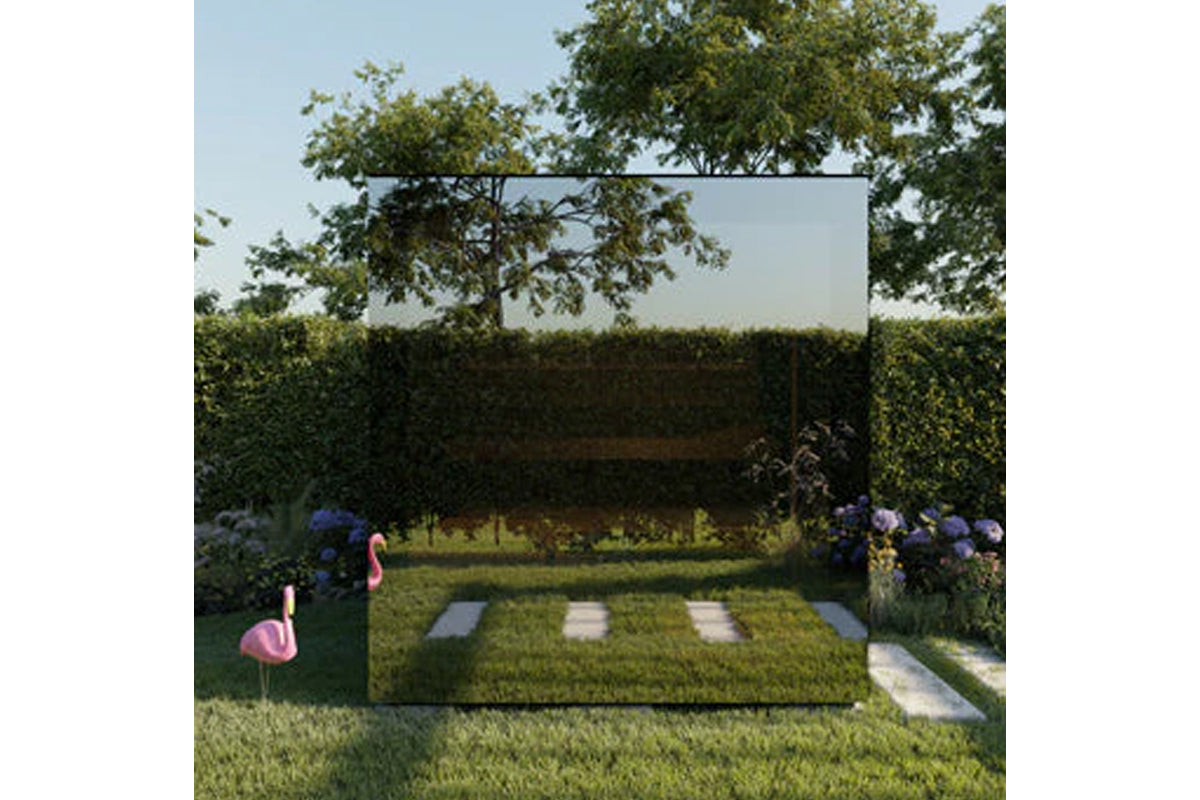 Modern outdoor sauna with black frame and frosted glass panels in garden setting surrounded by hedges and flowering plants