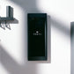 Black rectangular Tonal smart home gym display mounted on white wall with gray metal mounting bracket and cylindrical post