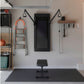 Black Tonal 2 Smart Home Gym mounted on white wall with cable pulley system and adjustable bench on mat, surrounded by fitnes
