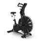 Black upright exercise air bike with large mesh fan wheel, padded seat, handlebar grips, and digital console on white backgro