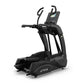Black TRUE elliptical machine with digital display console, curved foot pedals, and dual upper body handles on white backgrou