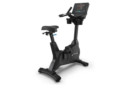 Black upright exercise bike with digital display console, padded seat, handlebars, and stable base on white background