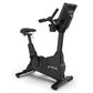 Black upright exercise bike with digital display console, padded seat, handlebars, and wheel base on white background