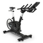 Black and silver Surge upright exercise bike with seat, handlebars, and digital console on white background
