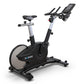 Black and silver upright exercise bike with digital display console, handlebars, and cushioned seat on white background