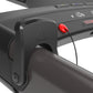 Black KICKR RUN smart treadmill with red stop button and digital display showing battery and time, angled view on white backg