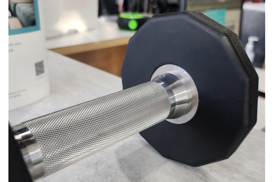 Black urethane 12-sided dumbbell with chrome knurled handle, displayed on white surface
