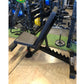 Black and gray weight bench with adjustable backrest, footrest, and black metal frame in gym setting
