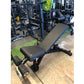 Black and blue adjustable weight bench with incline and decline positions, leg extension attachment, displayed in gym setting