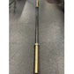 Warrior Black Cerakote and Gold Titanium Barbell with black shaft and gold sleeves, laid flat on gray background